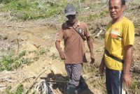 Pemilik lahan Desa Soligi, Alimusu (kanan), menunjukkan lokasi kebunnya yang diduga dijual sepihak oleh Kepala Desa Kawasi, sementara Alwani (depan) berdiri di atas lahannya seluas sekitar setengah hektare yang terdampak penggusuran tanpa kejelasan tanggung jawab dari Pemerintah Desa maupun PT Harita Group.